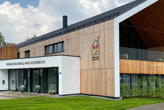 Modernes Ronald McDonald Haus Vogtareuth mit barrierefreiem Eingangsbereich, großem Schriftzug und Logo