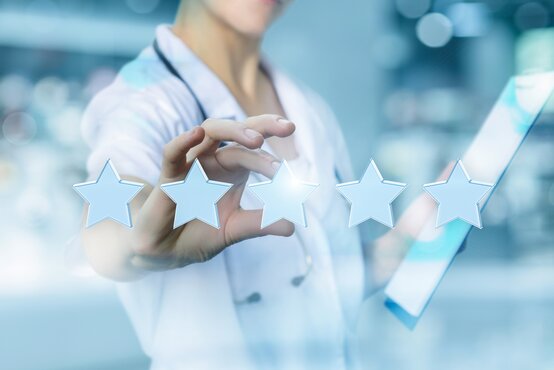 Ärztin bewertet fünf Sterne auf digitalem Display, Symbol für medizinische Qualität und Patientenzufriedenheit