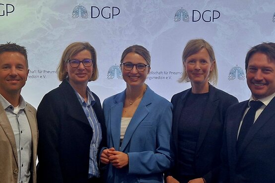 Fünf medizinische Fachkräfte, drei Frauen und zwei Männer, vor DGP-Logo auf Fachkonferenz